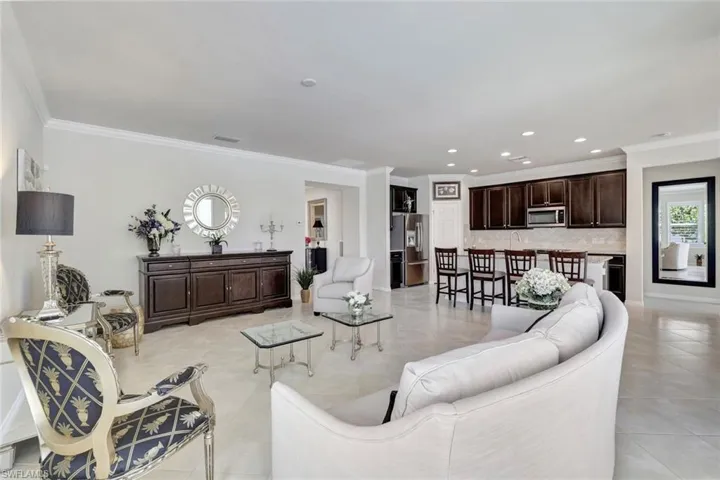Living room with recessed lighting, crown molding, and light tile patterned floors