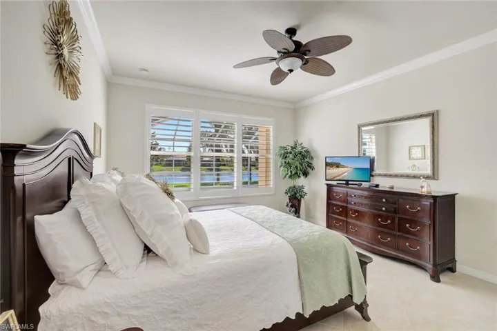 Bedroom with ornamental molding, multiple windows, ceiling fan, and light tile patterned floors
