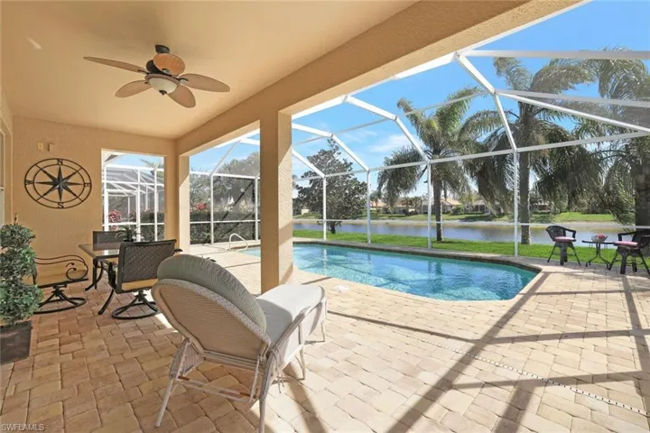 Pool featuring a patio area, a lanai, a ceiling fan, and a water view
