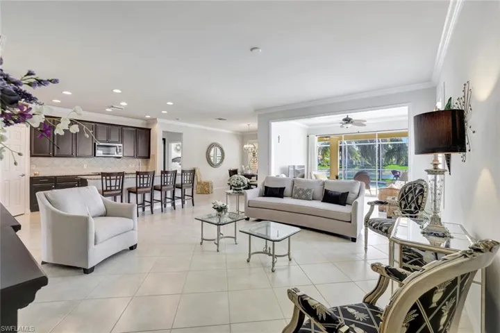 Living room featuring light tile patterned floors, recessed lighting, and crown molding