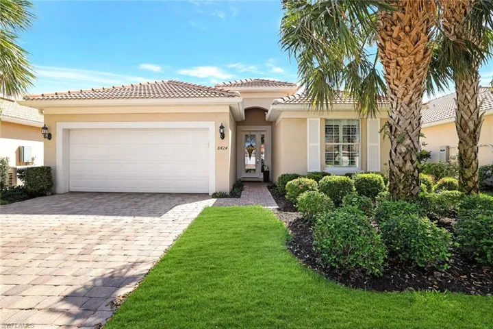 Mediterranean / spanish-style home with a garage, decorative driveway, a tile roof, and stucco siding