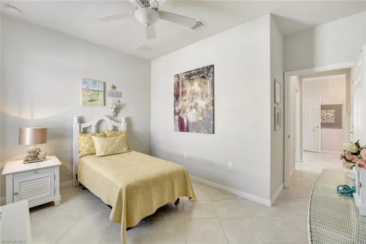 Bedroom featuring a ceiling fan, light tile patterned flooring, visible vents, and baseboards