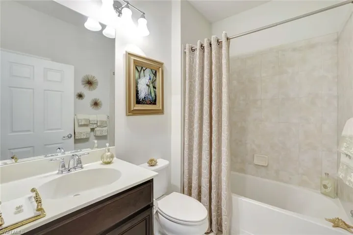Bathroom featuring toilet, shower / bath combo, and vanity