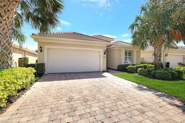 Mediterranean / spanish-style house with a garage, decorative driveway, a tiled roof, and stucco siding