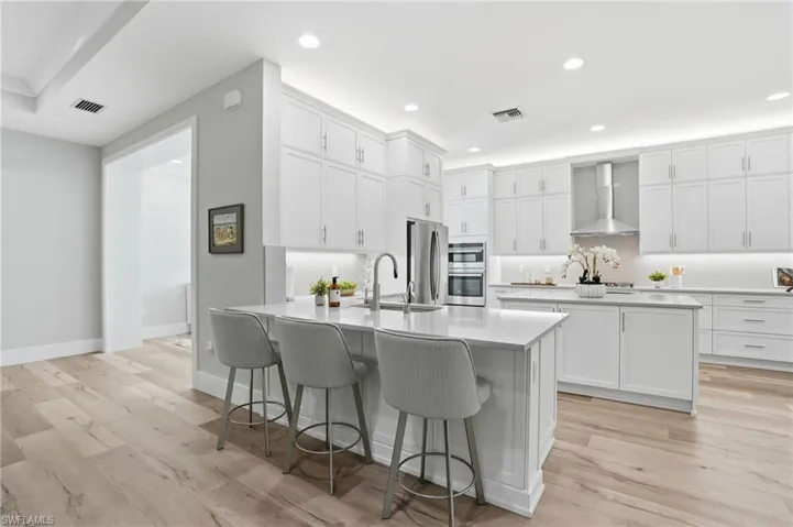 Massive kitchen with bar area, separate island and cabinets to the ceiling.