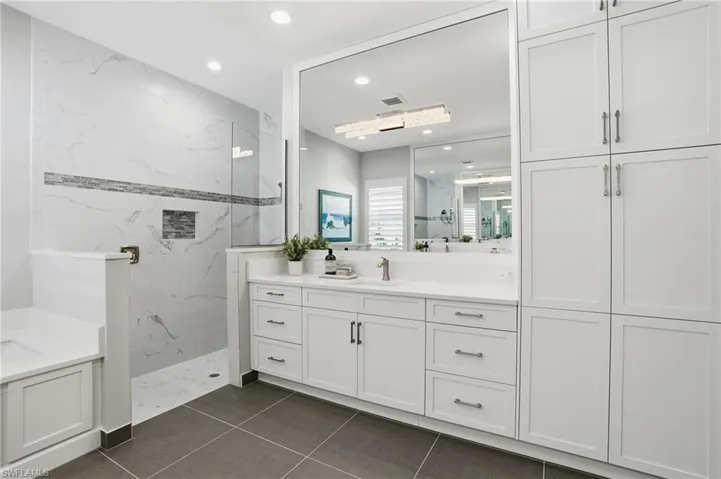 Soft close cabinets and framed mirror to the ceiling.
