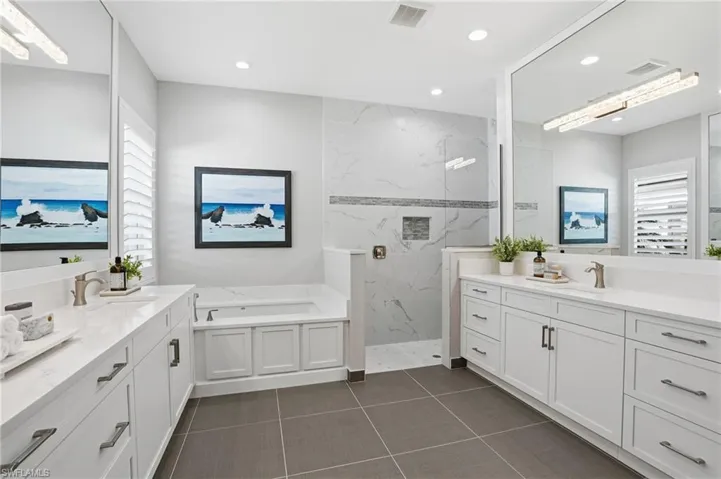 Dual sink vanities, Quartz countertops, Whirlpool tub and roman shower.