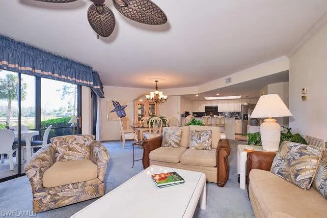 Living room featuring a chandelier, visible vents, and light carpet