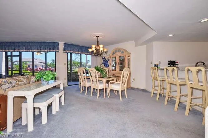 Dining area featuring carpet floors and an inviting chandelier