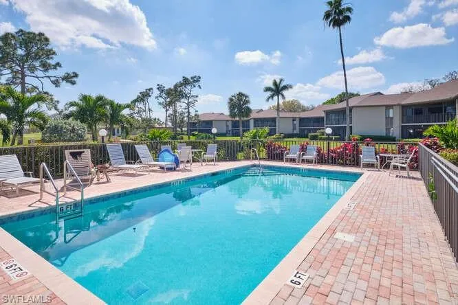 Community pool featuring fence and a patio