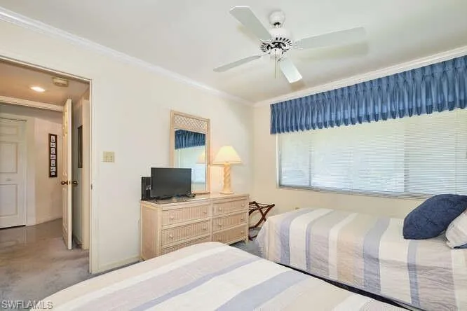 Bedroom featuring ceiling fan, ornamental molding, carpet flooring, and baseboards