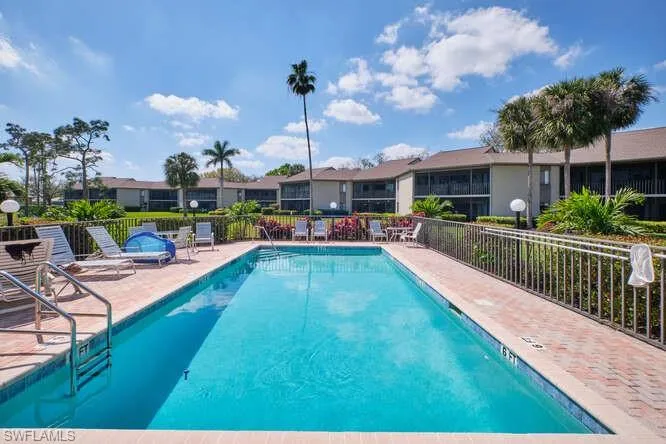 Community pool featuring a residential view, a patio area, and fence