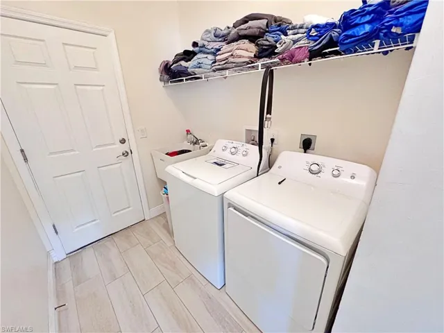 Laundry area featuring washing machine and dryer and wood finish floors