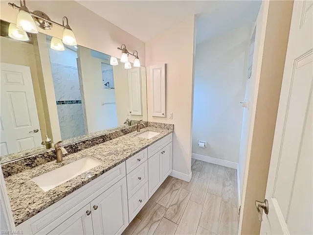 Primary Bathroom with double vanity and a walk in shower