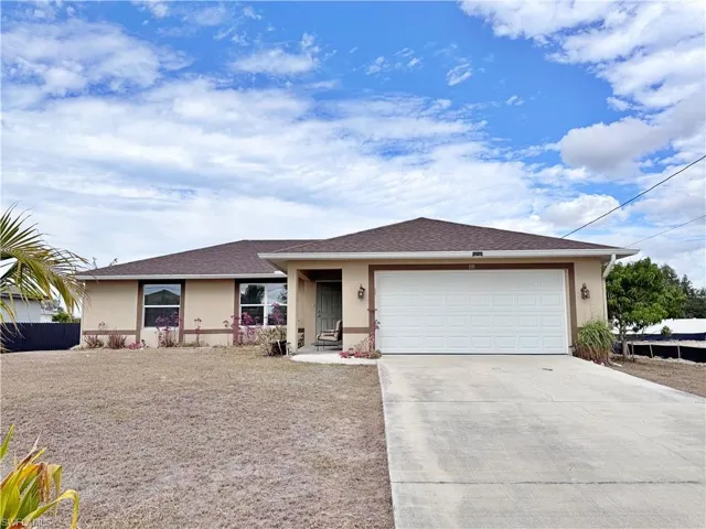 Ranch-style home featuring stucco siding, driveway, and a garage
