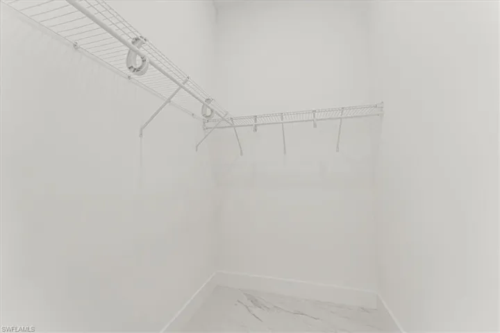 Spacious closet with light marble finish floors