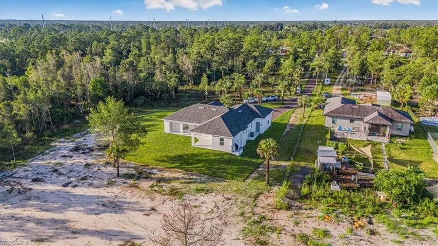 Aerial view of property and surrounding area featuring a heavily wooded area