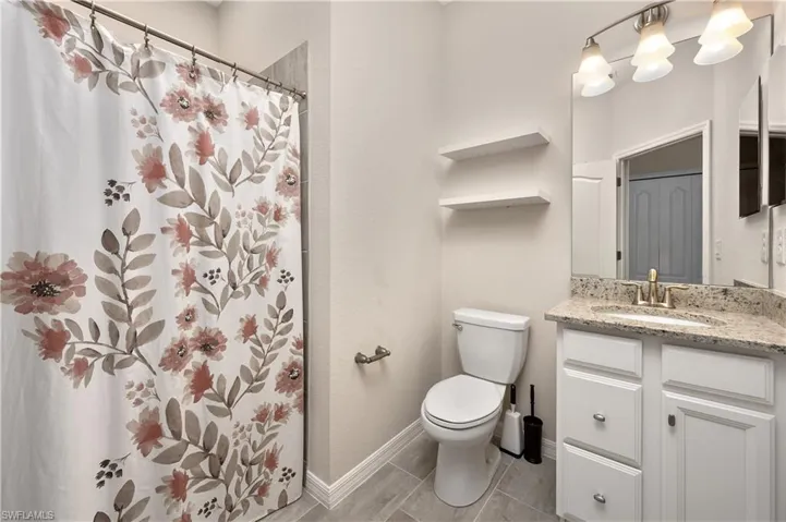 Bathroom with vanity, tile patterned floors, and toilet