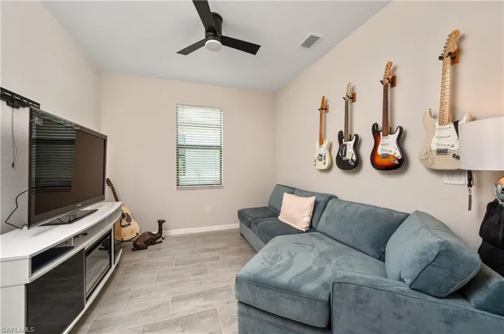 Living room with light tile patterned floors and ceiling fan