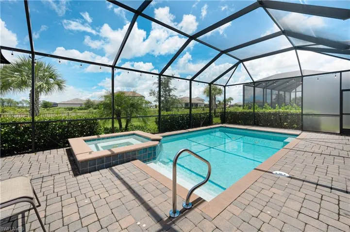 View of pool with an in ground hot tub, a patio area, and a lanai