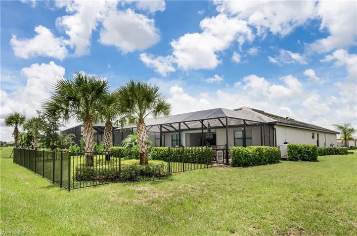 Back of property featuring a yard and a lanai
