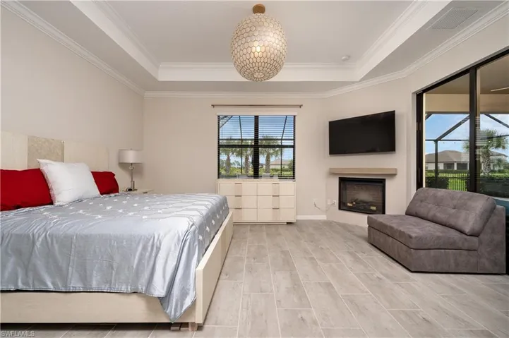 Bedroom with crown molding, a raised ceiling, and access to outside