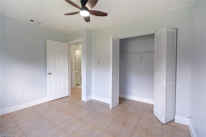 Room featuring neutral wall tones, tile flooring, and a ceiling fan with integrated lighting