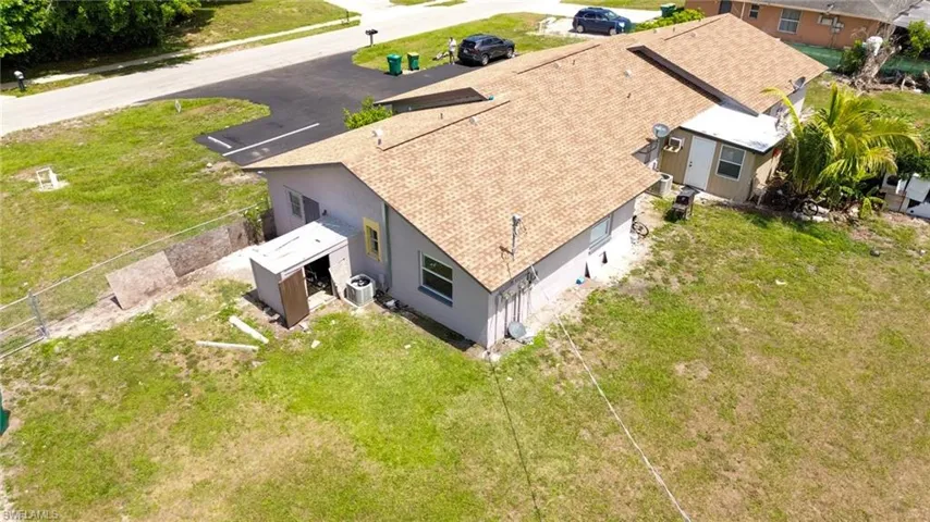 Single-story property featuring a tan shingle roof and light gray exterior siding