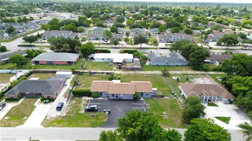 Aerial perspective showcasing multiple properties with paved driveways and surrounding mature landscaping