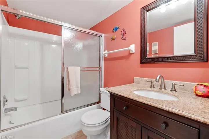 Bathroom featuring vanity and combined bath / shower with glass door
