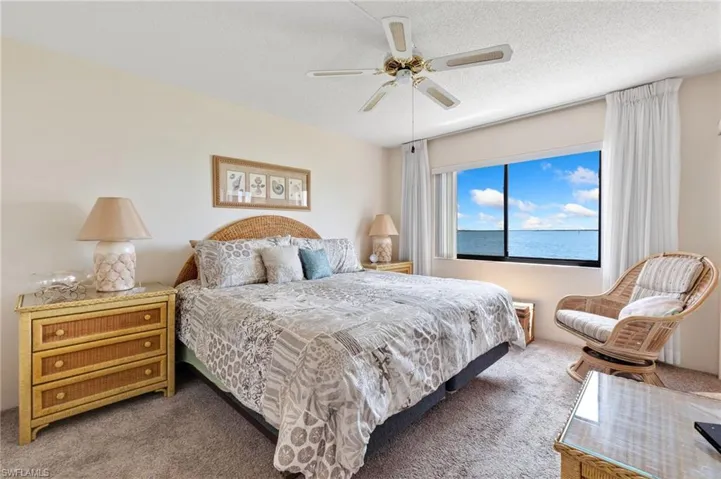 Carpeted bedroom with a ceiling fan and a textured ceiling