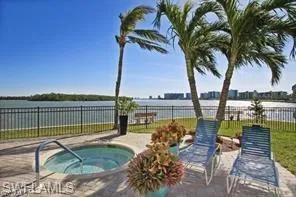 View of pool featuring a hot tub and a water view