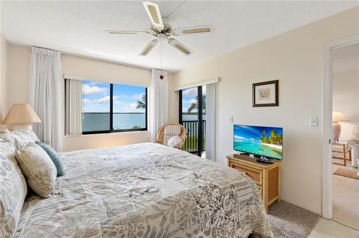 Bedroom featuring access to outside, a textured ceiling, ceiling fan, and light tile patterned flooring
