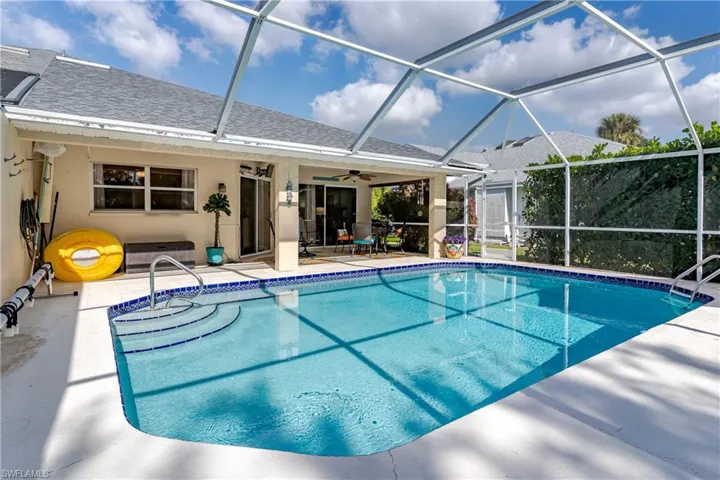Swimming pool with a lanai, a sunroom, ceiling fan, and a patio area