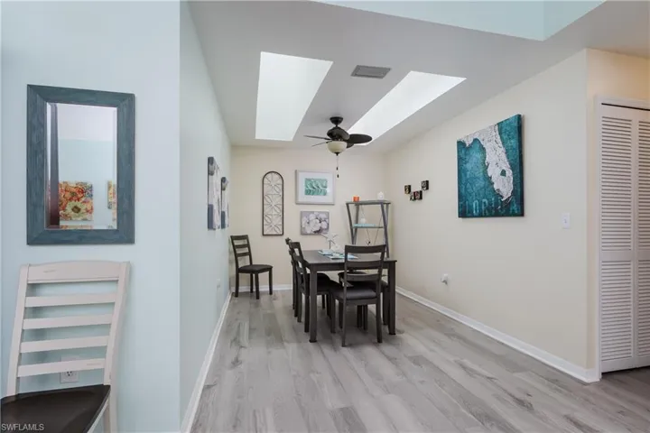 Dining area featuring ceiling fan, light wood-type flooring, and a skylight