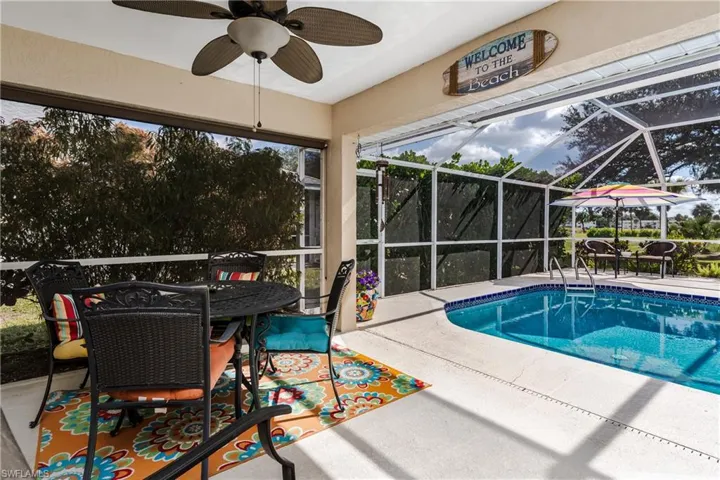 Outdoor pool with glass enclosure, a patio, a ceiling fan, outdoor dining space, and a sunroom
