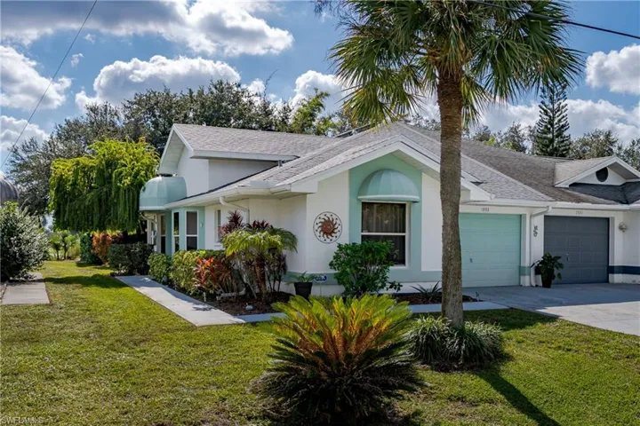 Ranch-style home featuring a front lawn, a shingled roof, concrete driveway, stucco siding, and an attached garage