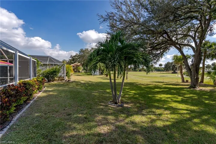 View of green lawn with a sunroom and a lanai