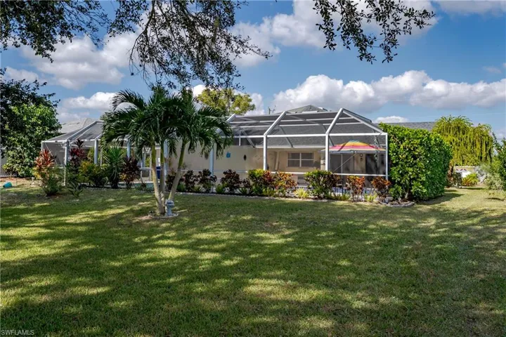 Outdoor pool with glass enclosure, a sunroom, and a patio area