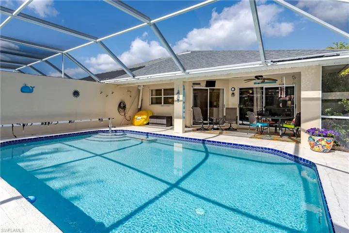 Outdoor pool with a ceiling fan, a sunroom, a patio area, and a lanai