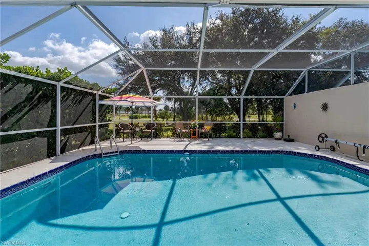 Swimming pool featuring glass enclosure and a sunroom