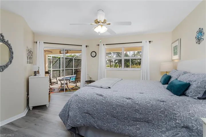 Bedroom featuring access to exterior, light wood finished floors, and a ceiling fan
