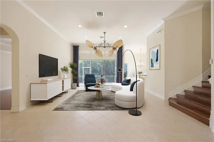 Great Room featuring light tile patterned floors, ornamental molding, and a chandelier