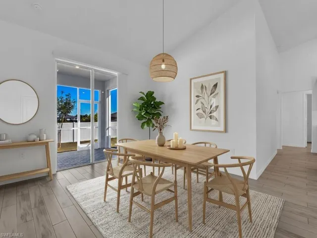 Dining room with light wood-type flooring and vaulted ceiling