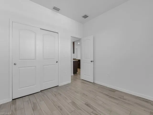 Unfurnished bedroom featuring light wood-style flooring and a closet