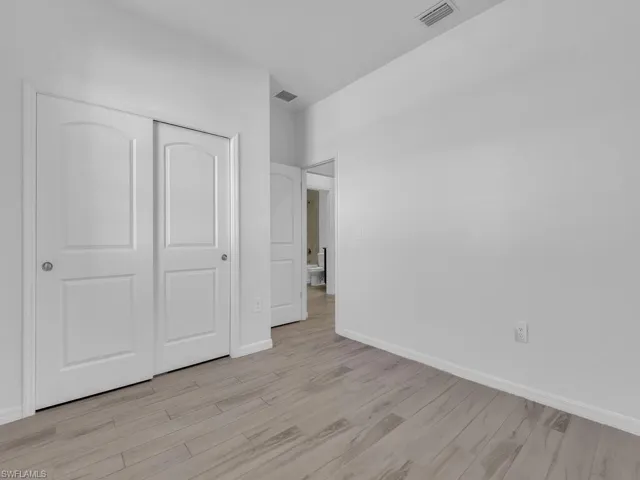 Unfurnished bedroom with light wood finished floors and a closet