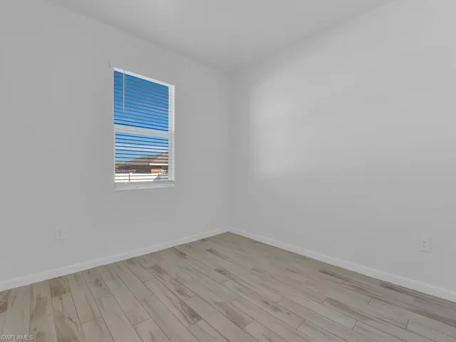 Unfurnished room with baseboards and light wood-style floors