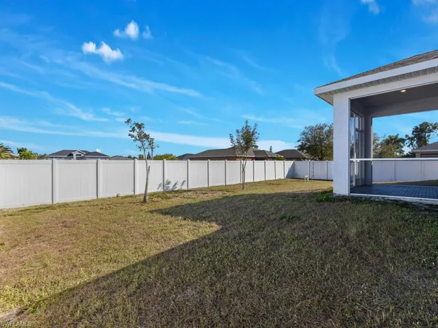 Fenced backyard featuring a sunroom