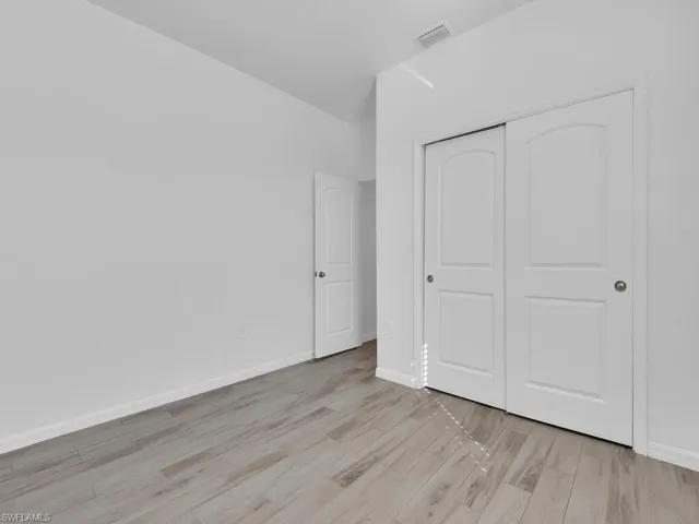 Unfurnished bedroom with light wood-style flooring and a closet