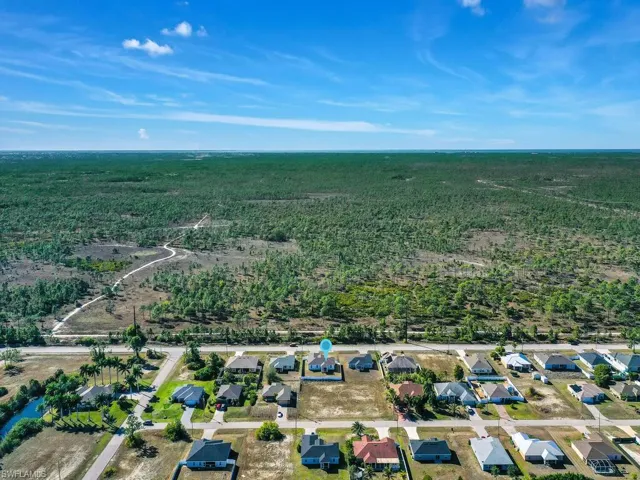 View of property location featuring a forest and nearby suburban area